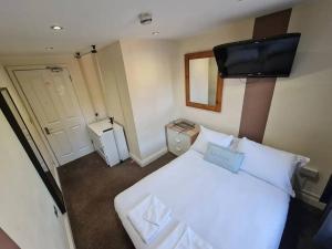 um quarto com uma cama branca e uma televisão de ecrã plano em Lovely bedroom em Londres