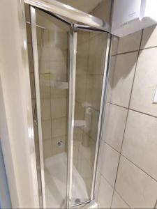 um chuveiro com uma porta de vidro na casa de banho em Lovely bedroom em Londres