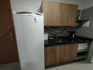 eine kleine Küche mit Kühlschrank und Spüle in der Unterkunft Flats em Condominio Velas do Porto in Porto De Galinhas