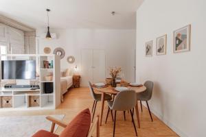 - un salon avec une table et des chaises dans l'établissement Virtudes Flat w/ AC & Balcony by LovelyStay, à Porto