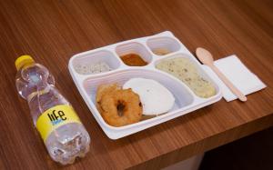 a plastic lunch box with food and a bottle of water at Grande Inn Trichy in Tiruchchirāppalli