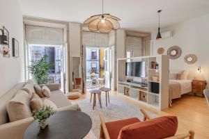 salon z kanapą i telewizorem w obiekcie Virtudes Flat w/ AC & Balcony by LovelyStay w Porto