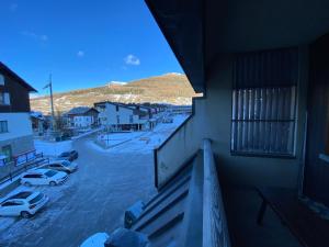 a balcony with a view of a parking lot with cars at BeSt Volpe in Sestriere