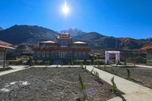 Muktināth的住宿－Lo Mustang Himalayan Resort，一座大建筑,背景是群山