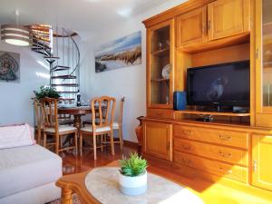 a living room with a television and a dining room at MCStylo-Ocean View in Caniço