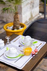 einen Tisch mit einem weißen Tischtuch mit Tellern und Gläsern in der Unterkunft Hotel les Armoiries in Valbonne