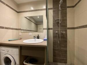 a bathroom with a sink and a shower and a washing machine at Bel appartement avec WiFi, balcon et garage à Perros-Guirec - FR-1-368-375 in Perros-Guirec +10 photos