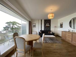 a living room with a table and chairs and a large window at Bel appartement avec WiFi, balcon et garage à Perros-Guirec - FR-1-368-375 in Perros-Guirec