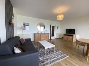 a living room with a blue couch and a table at Bel appartement avec WiFi, balcon et garage à Perros-Guirec - FR-1-368-375 in Perros-Guirec