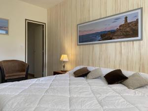 a bedroom with a large white bed with pillows at Bel appartement avec WiFi, balcon et garage à Perros-Guirec - FR-1-368-375 in Perros-Guirec