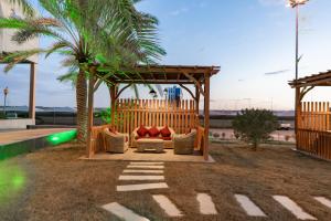 a gazebo with a couch and a palm tree at Le Park Concord - Sakaka in Sakakah