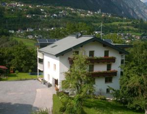 Un bâtiment blanc avec des fleurs sur son côté dans l'établissement Haus Raggl, à Landeck