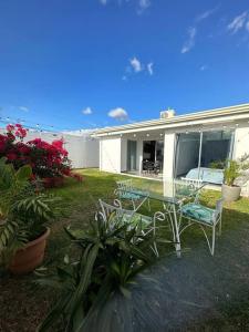 una casa con una mesa de cristal y sillas en un patio en Casa a 4km del aeropuerto SJO en Santiago Este