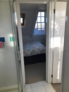 een kleine slaapkamer met een bed en een raam bij Cosy Loft Apartment in Georgian Home in Plymouth