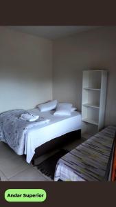 Hospedaria Recanto dos Pássaros في موريتيس: غرفة نوم مع سرير ورف كتاب