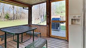 a screened in porch with a table and chairs at Hidden Forest Retreat in New Lisbon