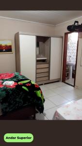 a bedroom with a bed and a dresser at Hospedaria Recanto dos Pássaros in Morretes
