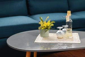a glass table with a bottle and flowers on it at Blerina Farm House in Laknas
