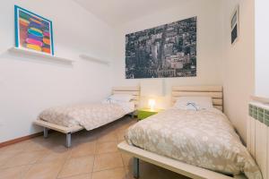 a bedroom with two beds and a painting on the wall at Appartamento Prima Fila Mare , La Vecchia Chiesa in Marotta