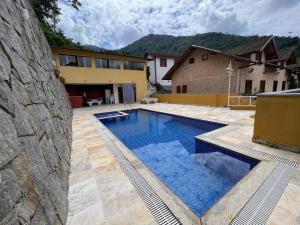 een zwembad in de achtertuin van een huis bij Casa com vista deslumbrante próximo a feirinha in Teresópolis