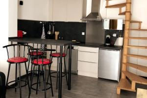 a kitchen with a counter and stools in it at petit logement Crecy la chapelle in Crécy-la-Chapelle