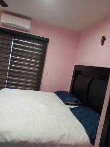 a bedroom with a white bed and a window at Hermosa casa Villa de la Abuela en Tampico in Tampico