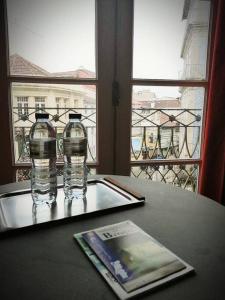 zwei Flaschen Wasser auf einem Tisch mit Fenster in der Unterkunft Sir Manuel Guest House - Unidade Centro Histórico in Braga