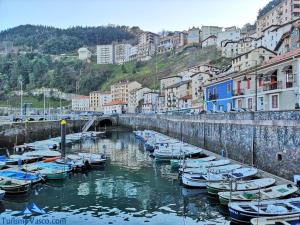 un grupo de barcos atracados en un río con edificios en Ibarrangelu Suite by Urdaibai Rentals, en Ibarrangelu