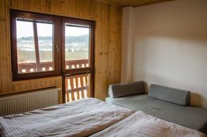 Schlafzimmer mit einem Bett und einem Fenster in der Unterkunft KROK in Horní Planá