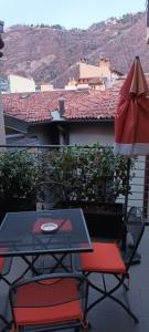 a table and chairs and an umbrella on a balcony at Como Via Carcano 13 in Como