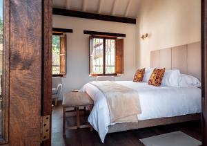 Schlafzimmer mit einem großen weißen Bett und Fenstern in der Unterkunft Hotel Casa Alcestre in Villa de Leyva