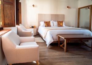 een slaapkamer met een bed, een stoel en een tafel bij Hotel Casa Alcestre in Villa de Leyva
