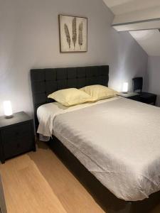 um quarto com uma cama grande e 2 mesas de cabeceira em Gîte chez Salvatore Vresse em Vresse-sur-Semois