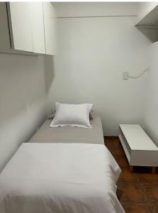 1 dormitorio con cama blanca y mesa en Amigable departamento en palermo en Buenos Aires