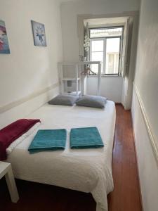 um quarto com uma cama com duas toalhas em Apartamento central para grupo ou familias em Lisboa