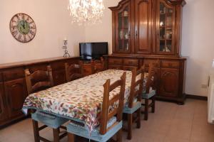 a dining room with a table and chairs and a clock at Casa nel Delta del Po in Scardovari