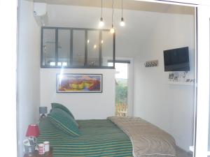 a bedroom with a bed and a television in it at Casa Vignes & Soleil in Puisserguier