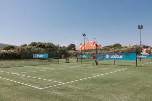 a tennis court with two tennis rackets on it at Valtur Baia dei Pini in Budoni