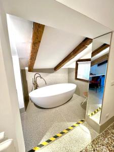 uma casa de banho com uma grande banheira branca num quarto em TRA SAN MARCO E RIALTO em Veneza