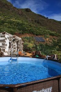 een groot blauw zwembad voor een berg bij La Chusmita in Valverde