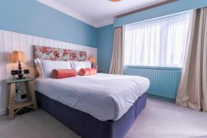 a blue bedroom with a large bed and a window at Hotel Collingwood BW Signature Collection in Bournemouth