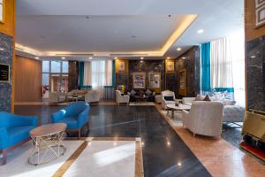 a lobby of a hotel with blue chairs and tables at Le Park Concord - Sakaka in Sakakah