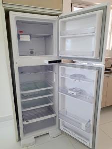 an empty refrigerator with its door open in a kitchen at Apt próx. Shopping Pantanal/Centro Político in Cuiabá
