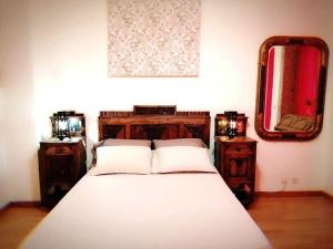 a bedroom with a bed with two night stands and a mirror at Sir Manuel Guest House - Unidade Centro Histórico in Braga