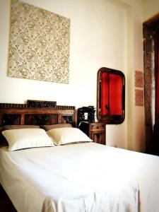 Schlafzimmer mit einem Bett und einem Wandspiegel in der Unterkunft Sir Manuel Guest House - Unidade Centro Histórico in Braga