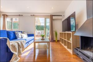 ein Wohnzimmer mit einem blauen Sofa und einem Kamin in der Unterkunft WOOOW!!! Àtic Cèntric amb Terrassa in Tarragona
