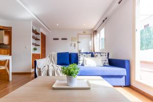 a living room with a blue couch and a table at WOOOW!!! Àtic Cèntric amb Terrassa in Tarragona