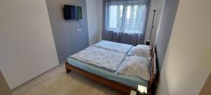 a small bed in a room with a window at Laguna Beach Apartmanok in Siófok +42 photos