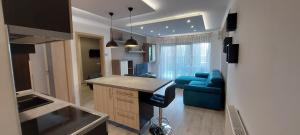 a kitchen and living room with a blue couch at Laguna Beach Apartmanok in Siófok