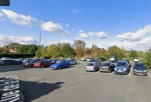 a parking lot filled with lots of parked cars at Hôtel - Restaurant "Histoire de Bistrot" in Isbergues